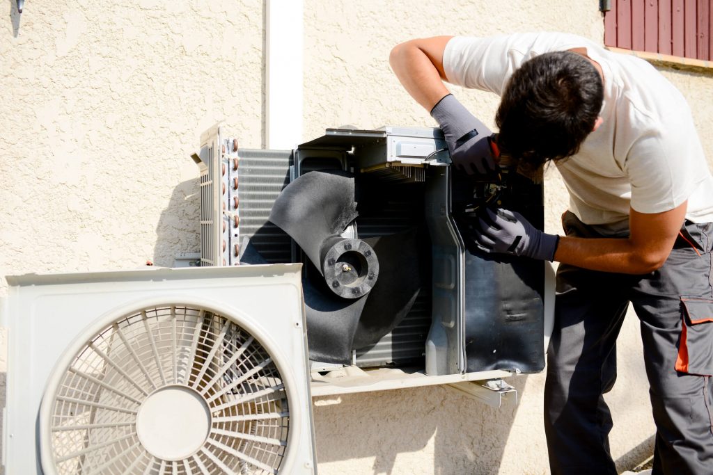technician repairing air conditioner